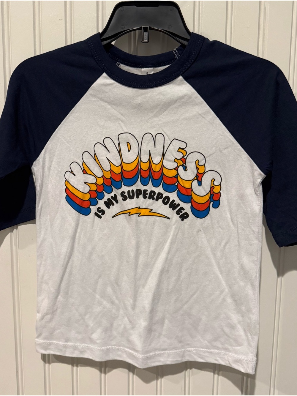 Rivet Apparel White and Navy Raglan Tee with Retro 'Kindness' Graphic